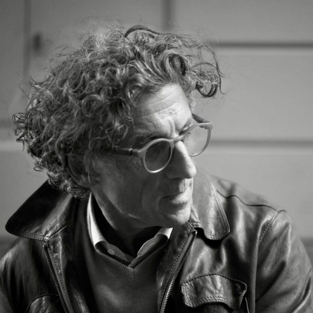 Black and white portrait of artist Andrea Federico Santicoli wearing glasses and leather jacket.