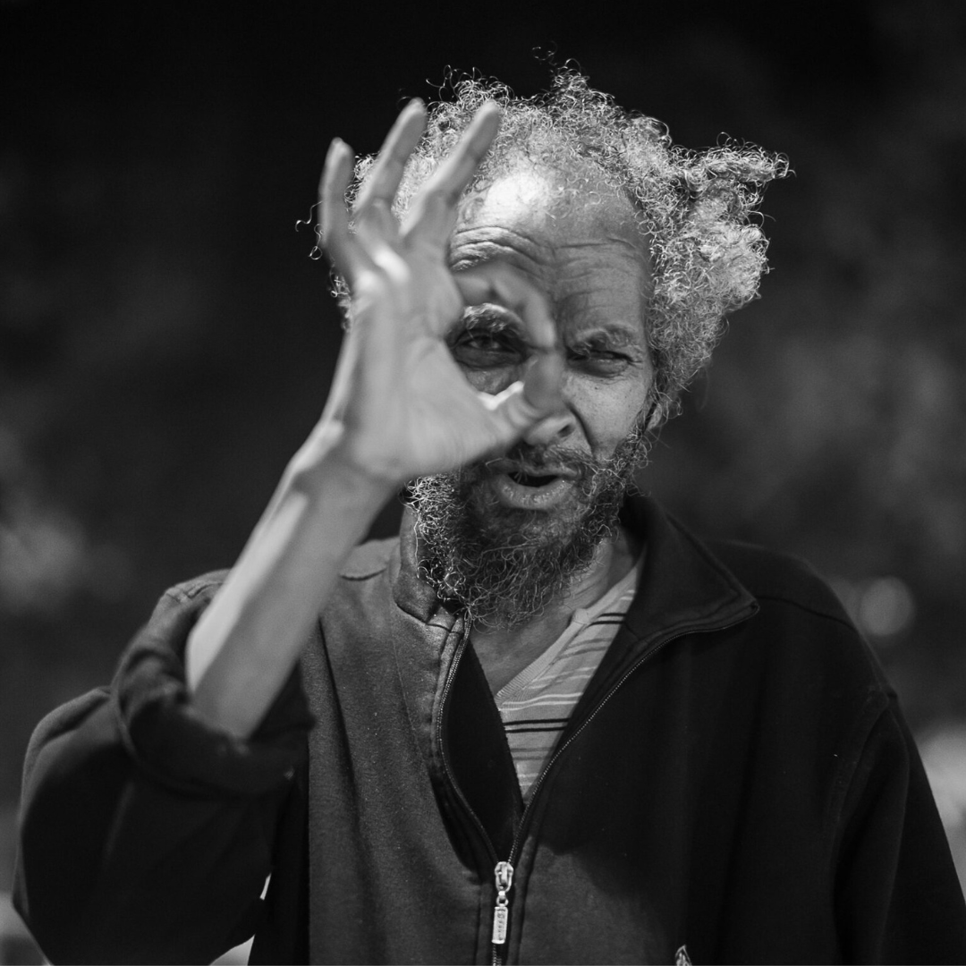 Portrait of expressive man making a circle gesture around his eye, black and white photography by Andrea Federico Santicoli