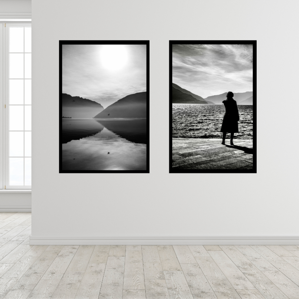 Black and white fine art photographic prints displayed on a minimalist interior wall, showing a serene landscape and a solitary human figure, photographed by Andrea Federico Santicoli.