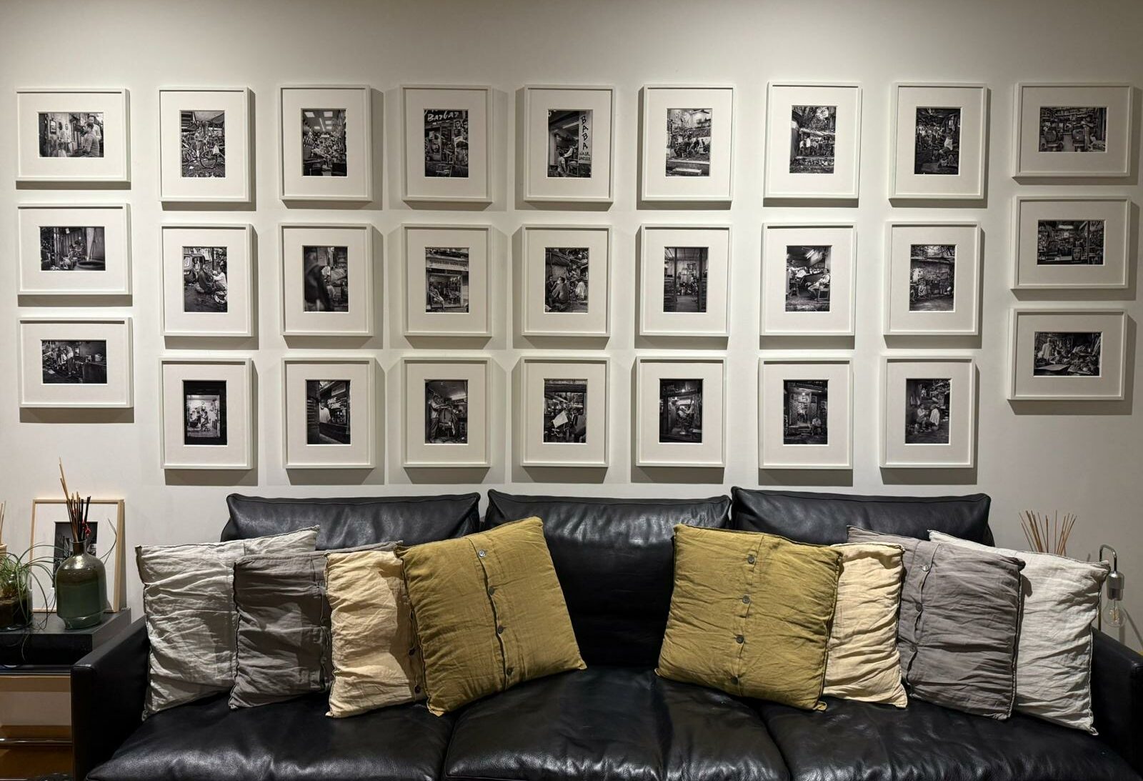 Stampe fotografiche artistiche in bianco e nero disposte come una galleria sopra un divano in un interno contemporaneo, fotografate da Andrea Federico Santicoli.