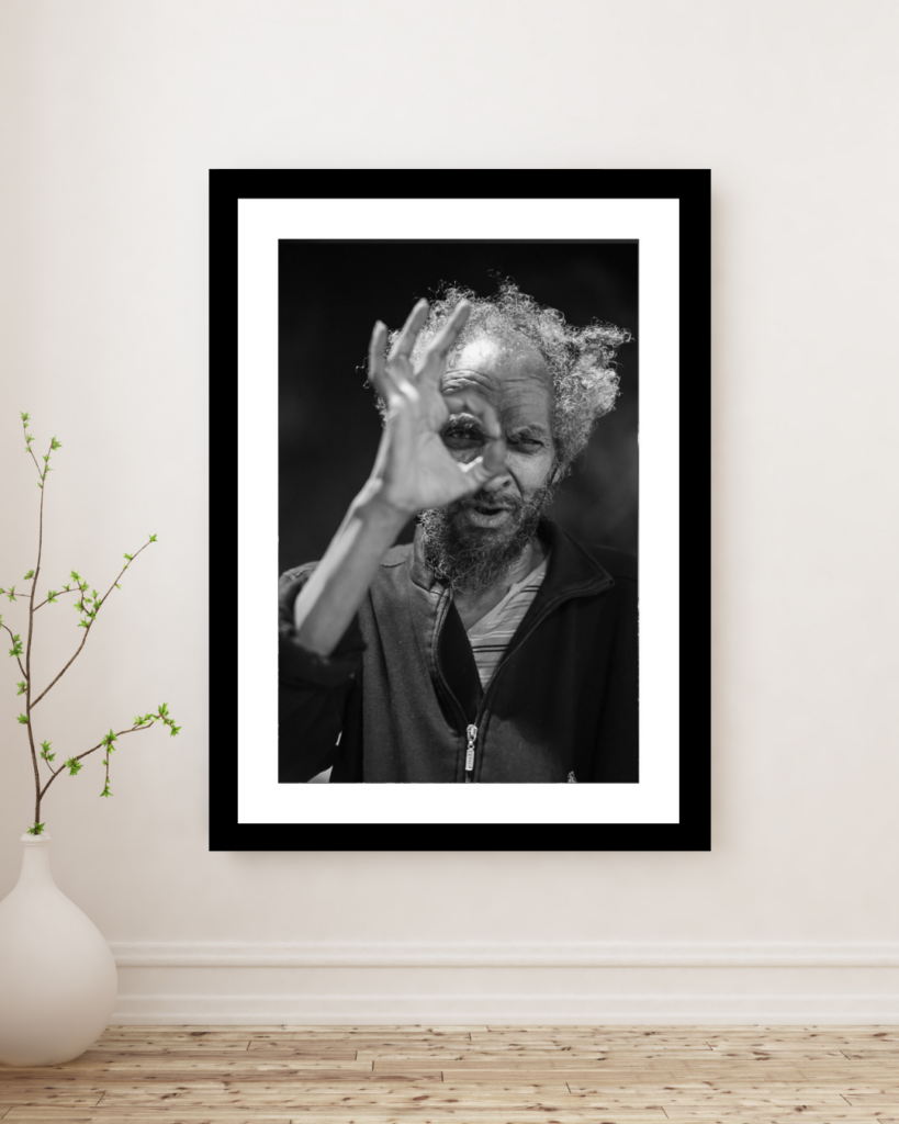 Black and white fine art portrait print displayed in a minimalist interior, featuring an expressive man framed on a wall, photographed by Andrea Federico Santicoli.